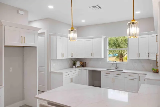 a kitchen with kitchen island granite countertop a sink a counter space appliances and cabinets