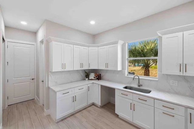 a kitchen with a sink window and cabinets