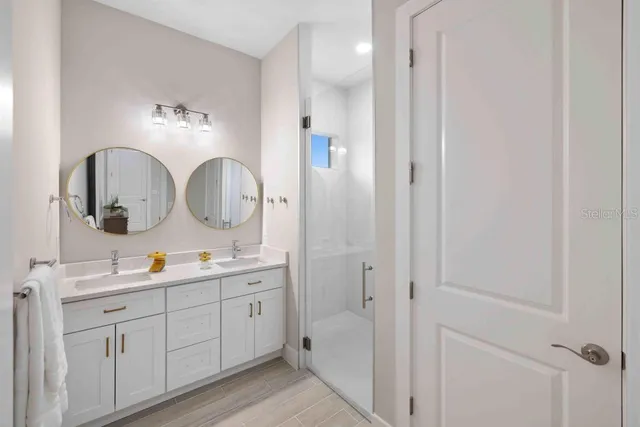 a en suite bathroom with a double vanity sink and a mirror