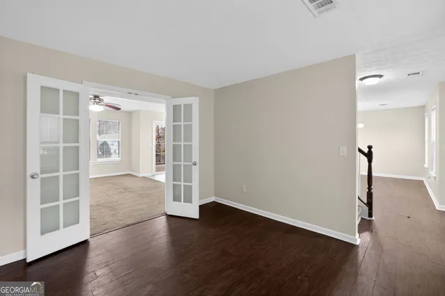 an empty room with wooden floor and windows