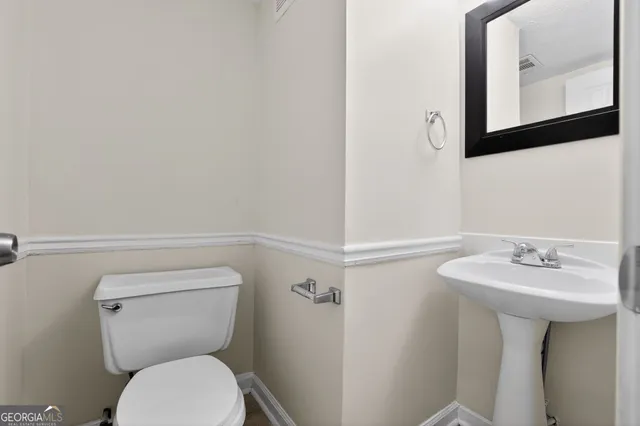 a bathroom with a toilet a sink and mirror