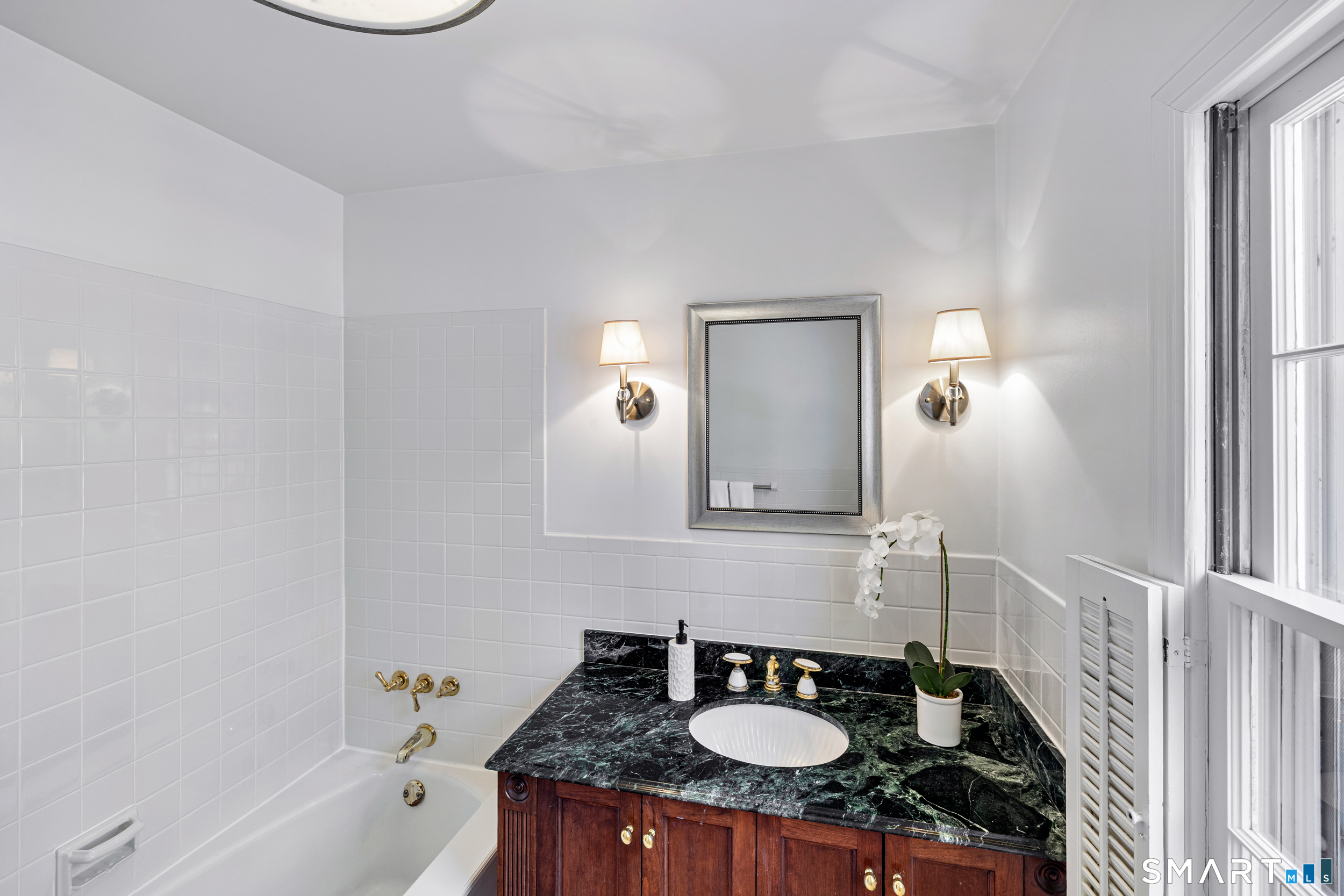 1038 West Road New Canaan, CT 06840 - Photo 28 of 37 a bathroom with a sink and a mirror