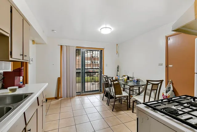 a kitchen with a stove and chairs