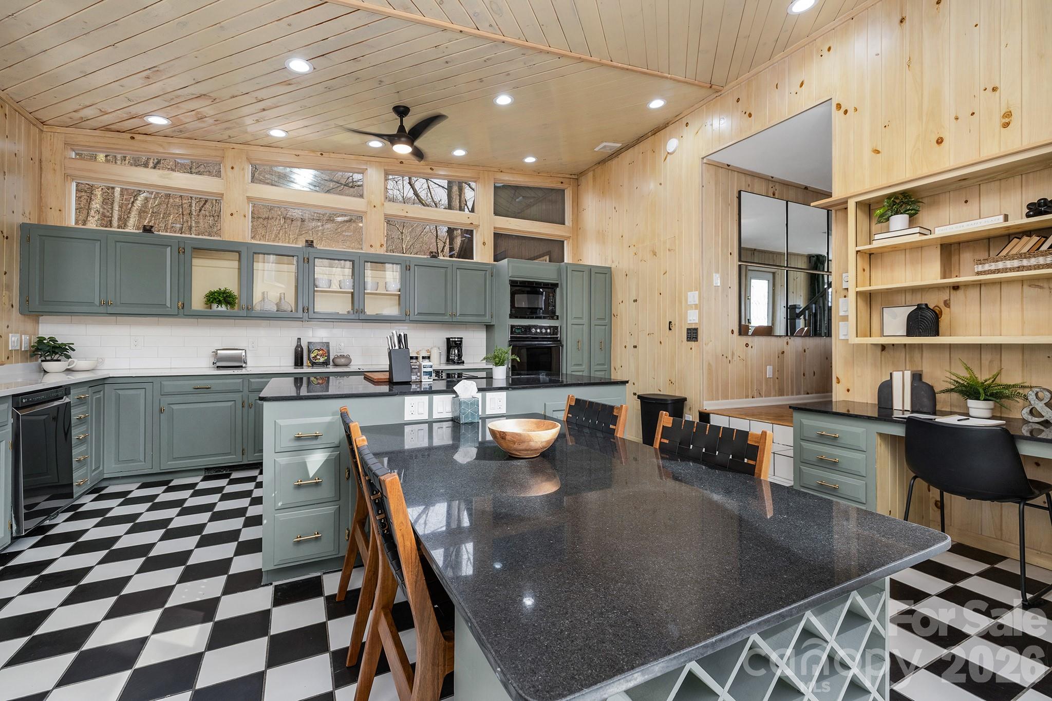 556-558 Thorncliff Drive Seven Devils, NC 28604 - Photo 27 of 48 a kitchen with stainless steel appliances granite countertop a stove a sink a refrigerator white cabinets a dining table and chairs