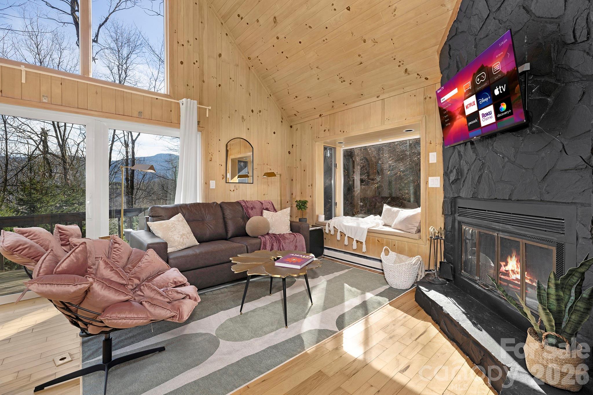 556-558 Thorncliff Drive Seven Devils, NC 28604 - Photo 39 of 48 a living room with furniture a fireplace and a floor to ceiling window