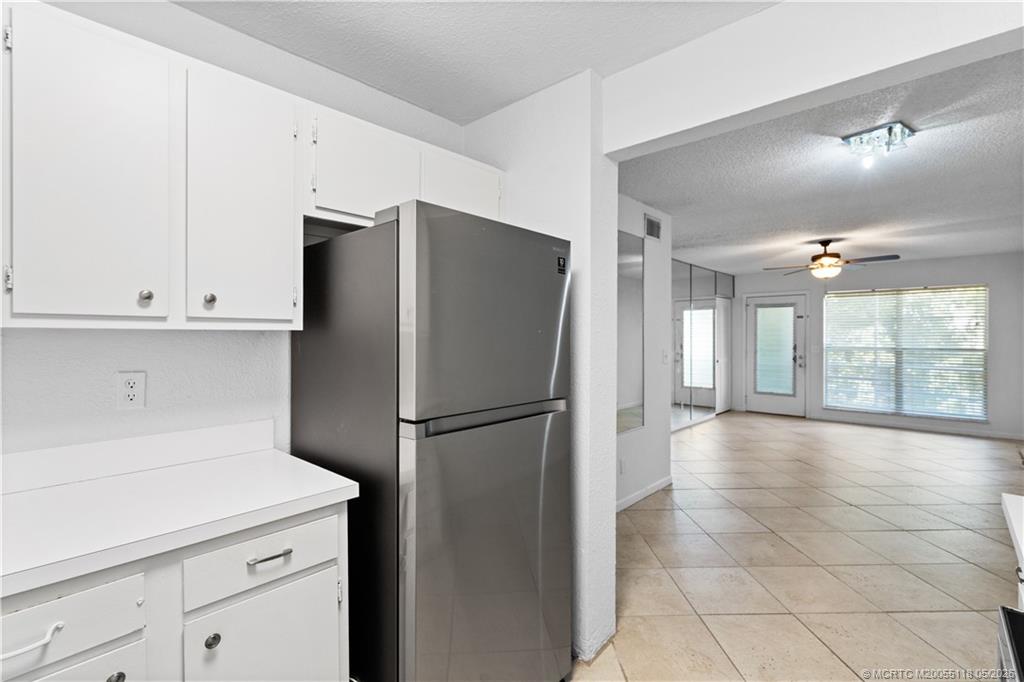 2118 Southeast Edler Drive, Unit B Stuart, FL 34994 - Photo 9 of 20 a kitchen with a refrigerator a stove top oven and cabinets