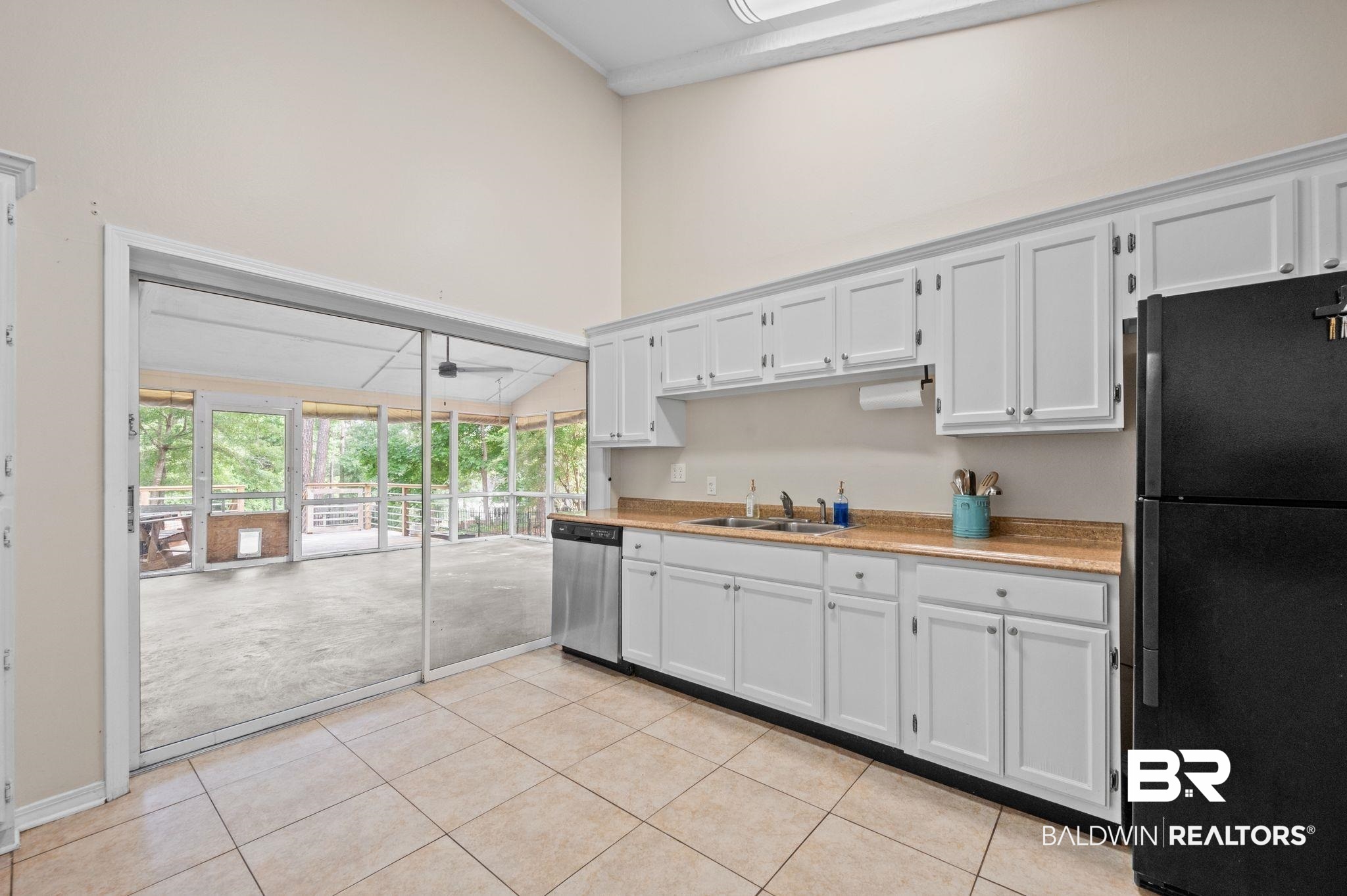 110 Ferncliff Circle Daphne, AL 36526 - Photo 17 of 40 Kitchen featuring freestanding refrigerator, dishwasher, a sink, light countertops, and a high ceiling