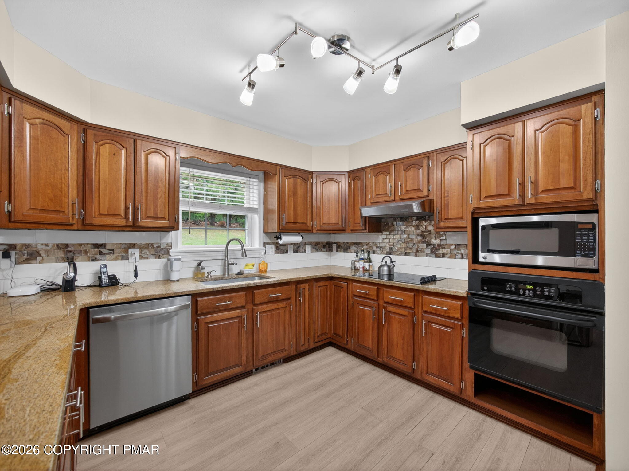 363 Blue Ridge Road Saylorsburg, PA 18353 - Photo 27 of 61 a kitchen with stainless steel appliances granite countertop wooden cabinets a sink a stove a refrigerator and island with wooden floor