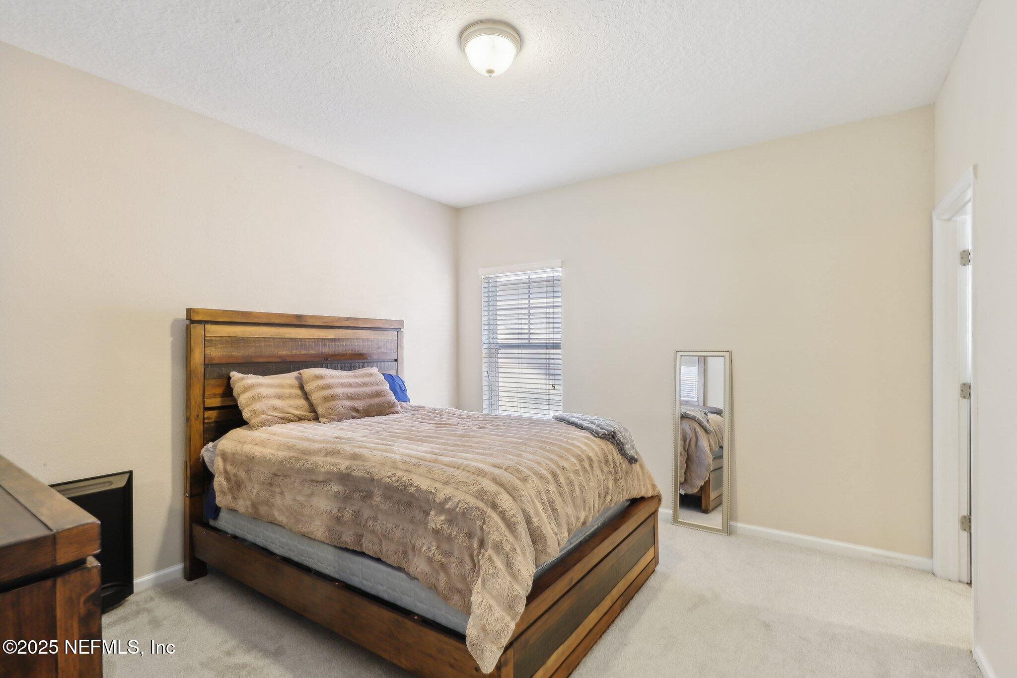 2171 Eagle Talon Circle Fleming Island, FL 32003 - Photo 25 of 44 a bedroom with a bed and cabinet