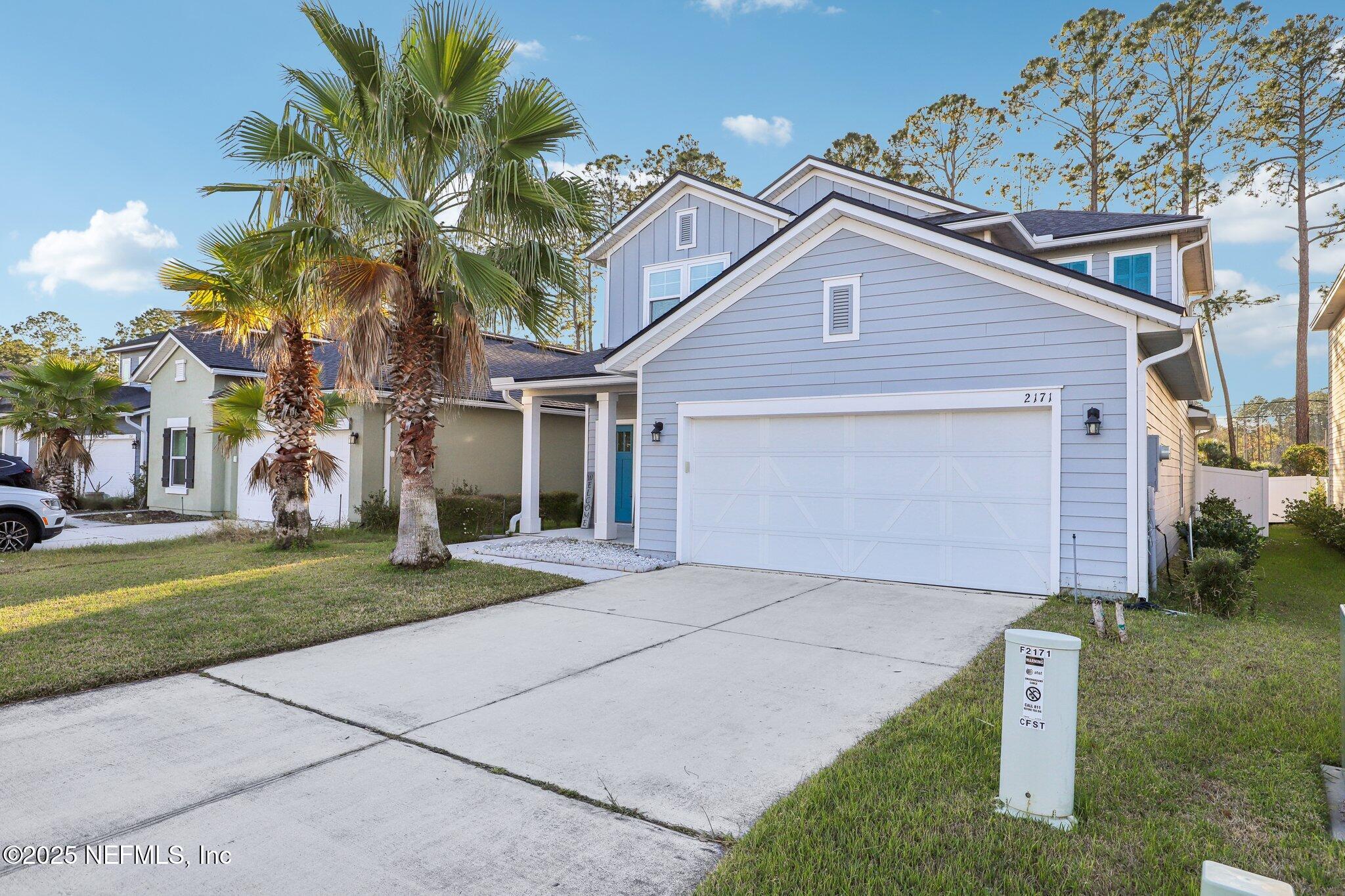 2171 Eagle Talon Circle Fleming Island, FL 32003 - Photo 3 of 44 a front view of a house with a yard and a garage