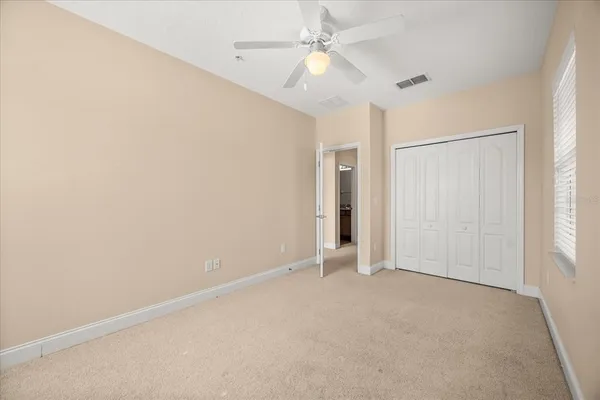 an empty room with fan and windows