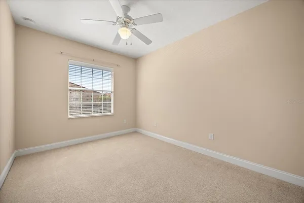 an empty room with a window and ceiling fan