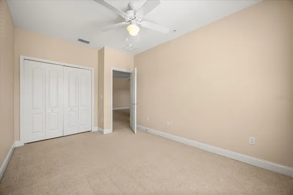 an empty room with a ceiling fan and a window