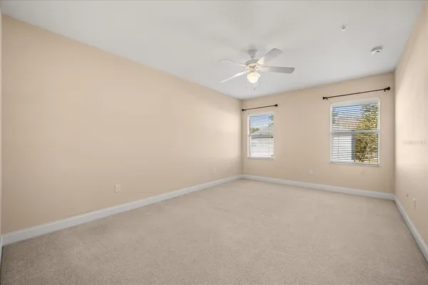 an empty room with a window and ceiling fan