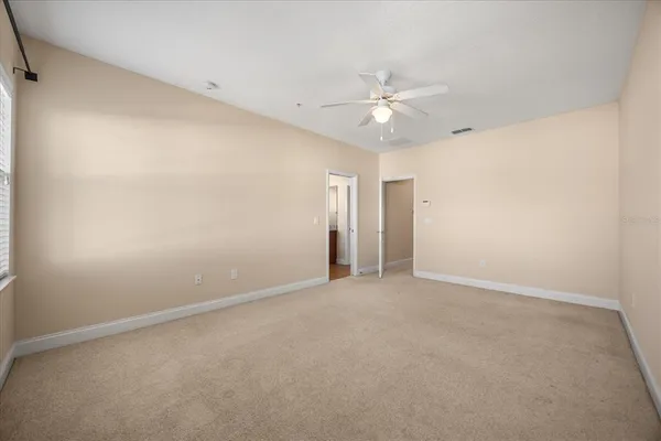 an empty room with a ceiling fan and a window