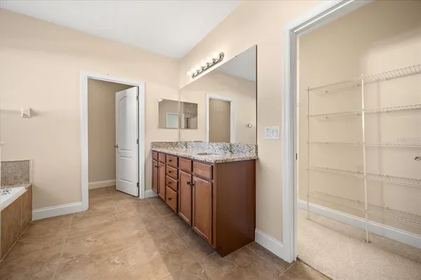a bathroom with a granite countertop sink mirror and bathtub