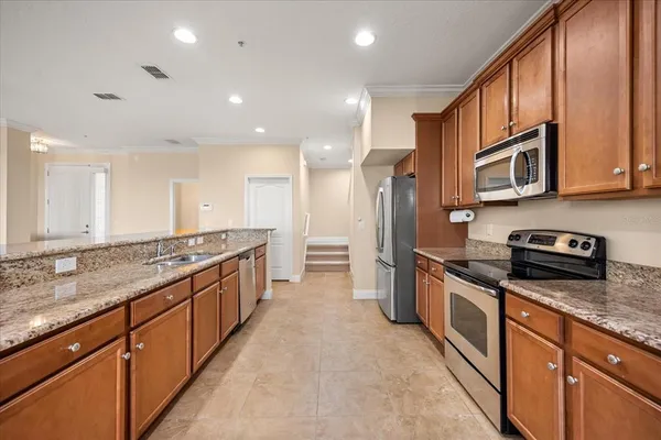 a large kitchen with stainless steel appliances granite countertop a stove a sink and a refrigerator