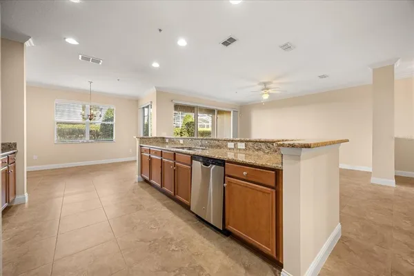 a large kitchen with stainless steel appliances granite countertop a large stove a sink a refrigerator and white cabinets