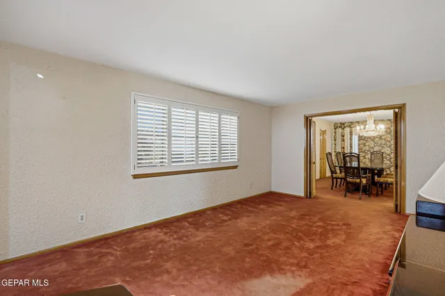 a view of a livingroom with furniture and chandelier fan