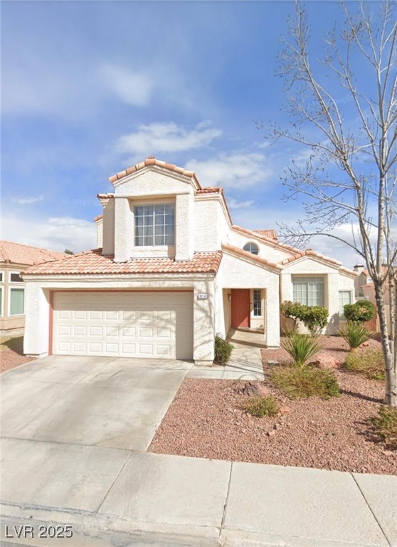 Mediterranean / spanish-style house featuring concrete driveway, a garage, stucco siding, and a tile roof
