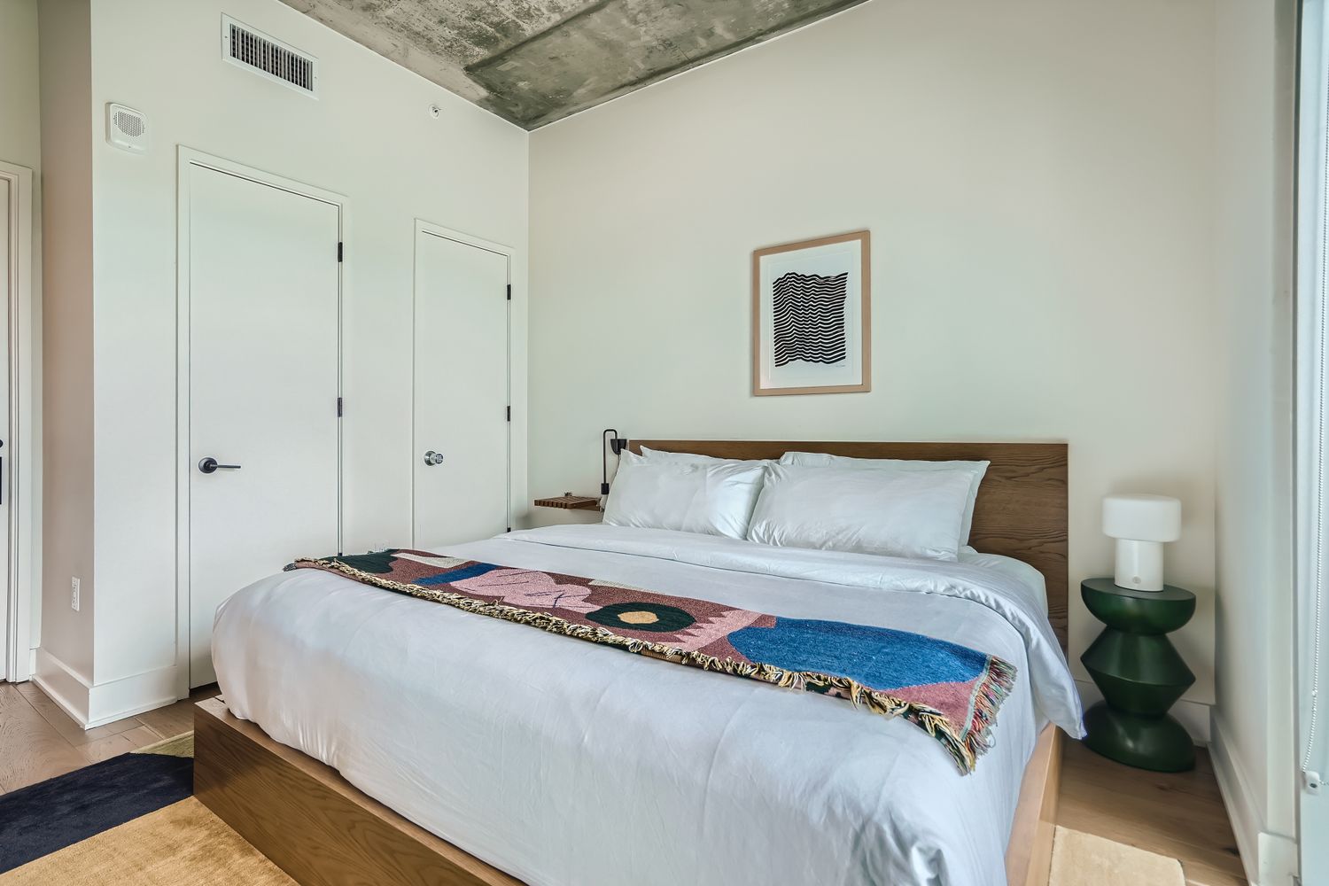 48 East Avenue, Unit 1706 Austin, TX 78701 - Photo 10 of 12 a bedroom with a bed and a night stand