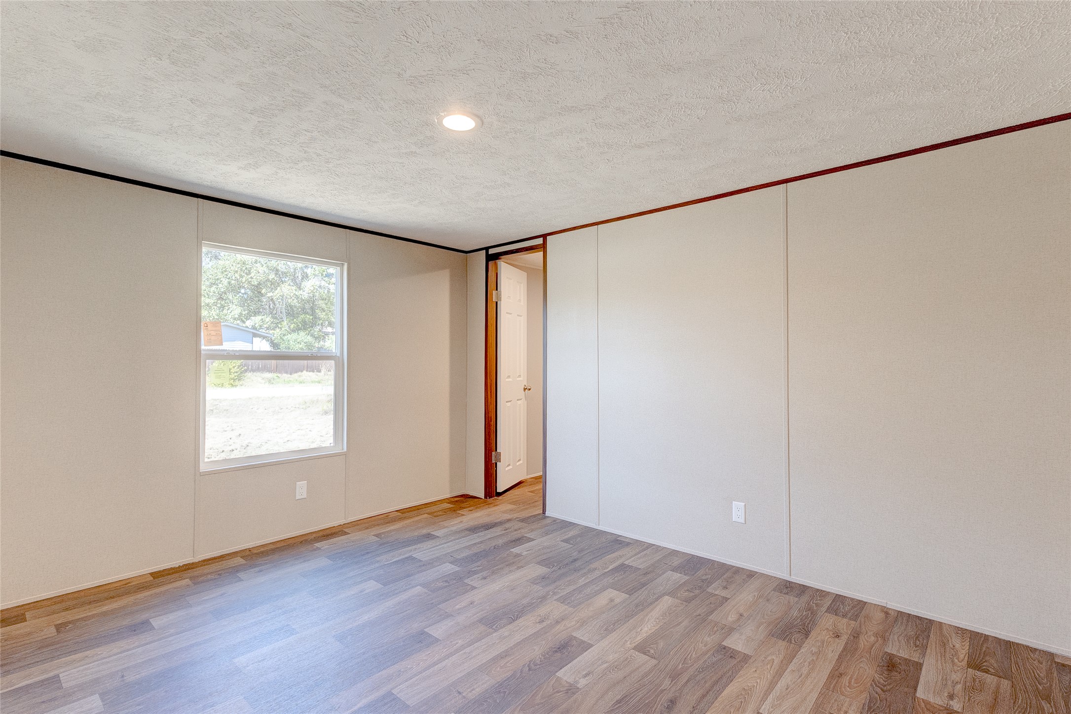 107 Los Cueva Road Elgin, TX 78621 - Photo 20 of 31 Empty room with a textured ceiling, light wood-style floors, and crown molding