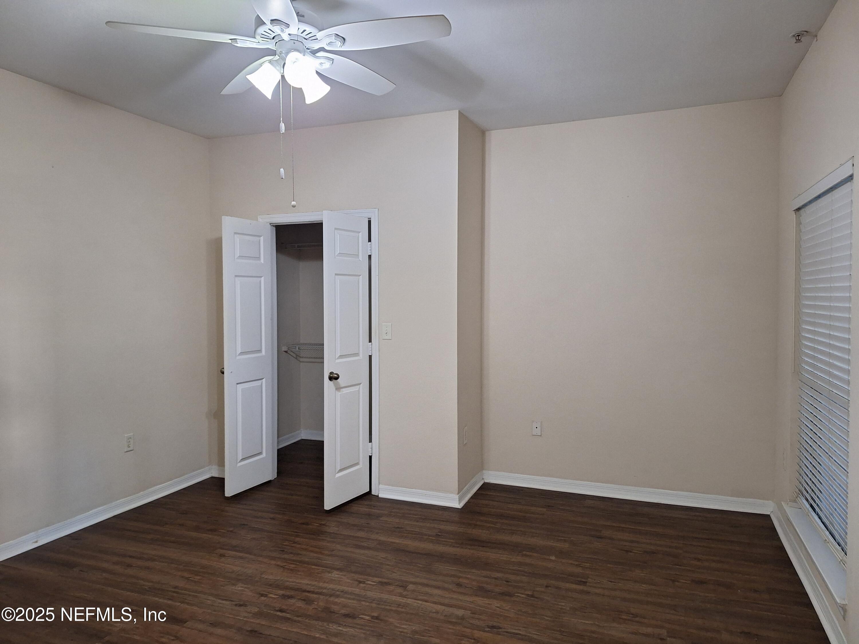 7800 Point Meadows Drive, Unit 116 Jacksonville, FL 32256 - Photo 13 of 29 a view of an empty room with wooden floor and a ceiling fan
