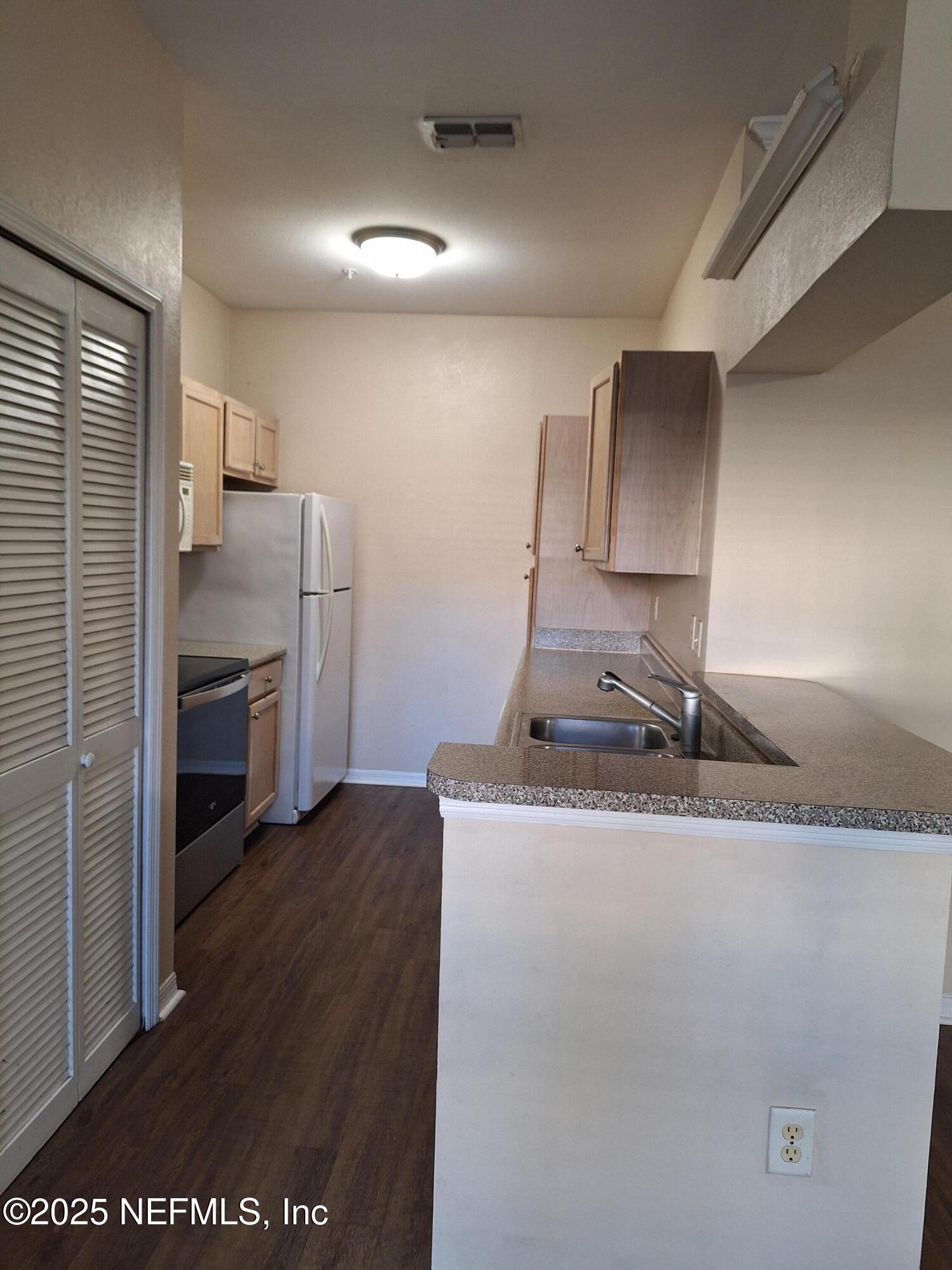 7800 Point Meadows Drive, Unit 116 Jacksonville, FL 32256 - Photo 19 of 29 a kitchen with stainless steel appliances granite countertop a refrigerator a sink and a stove