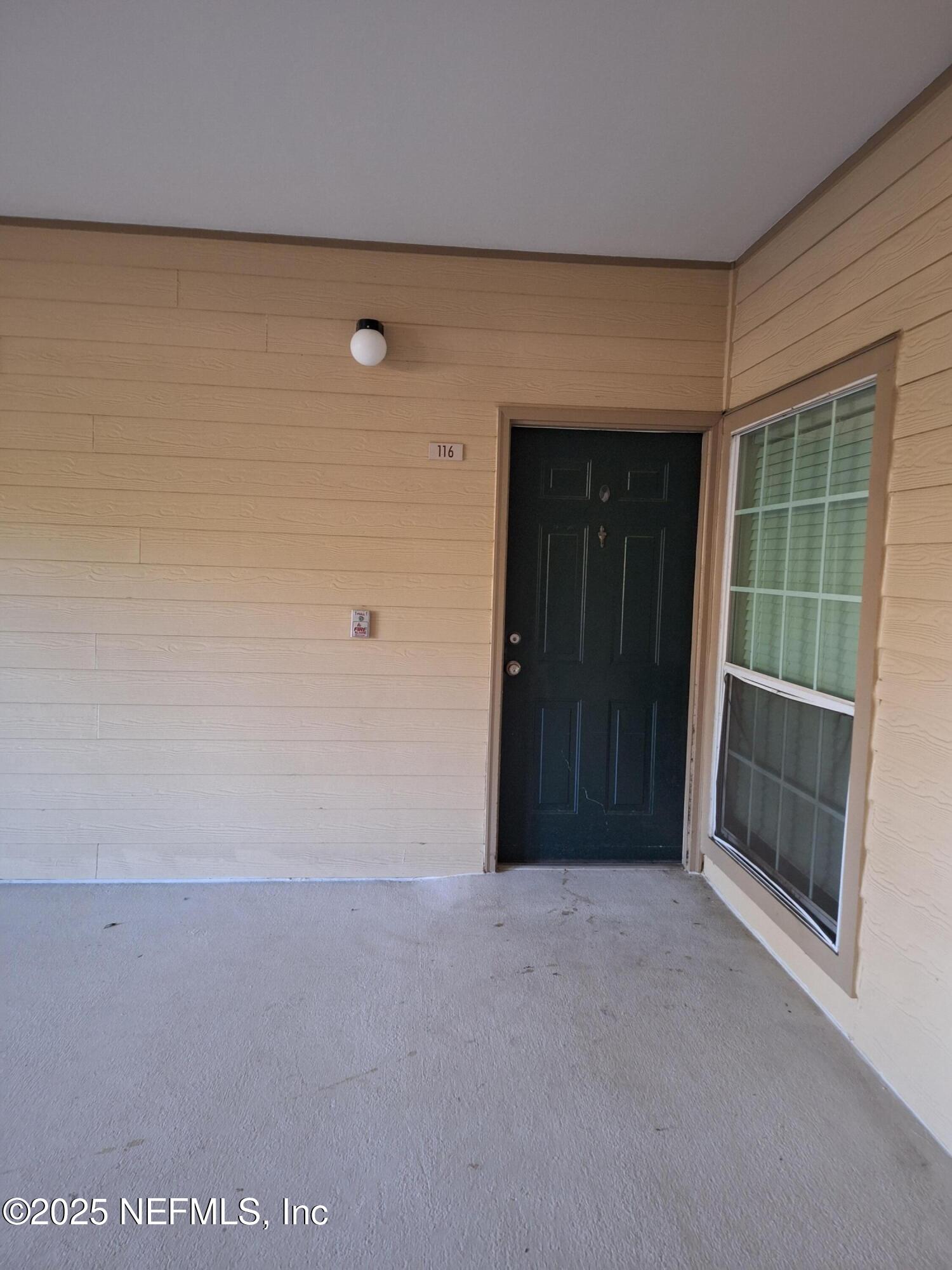 7800 Point Meadows Drive, Unit 116 Jacksonville, FL 32256 - Photo 7 of 29 a view of an empty room with wooden floor and a window