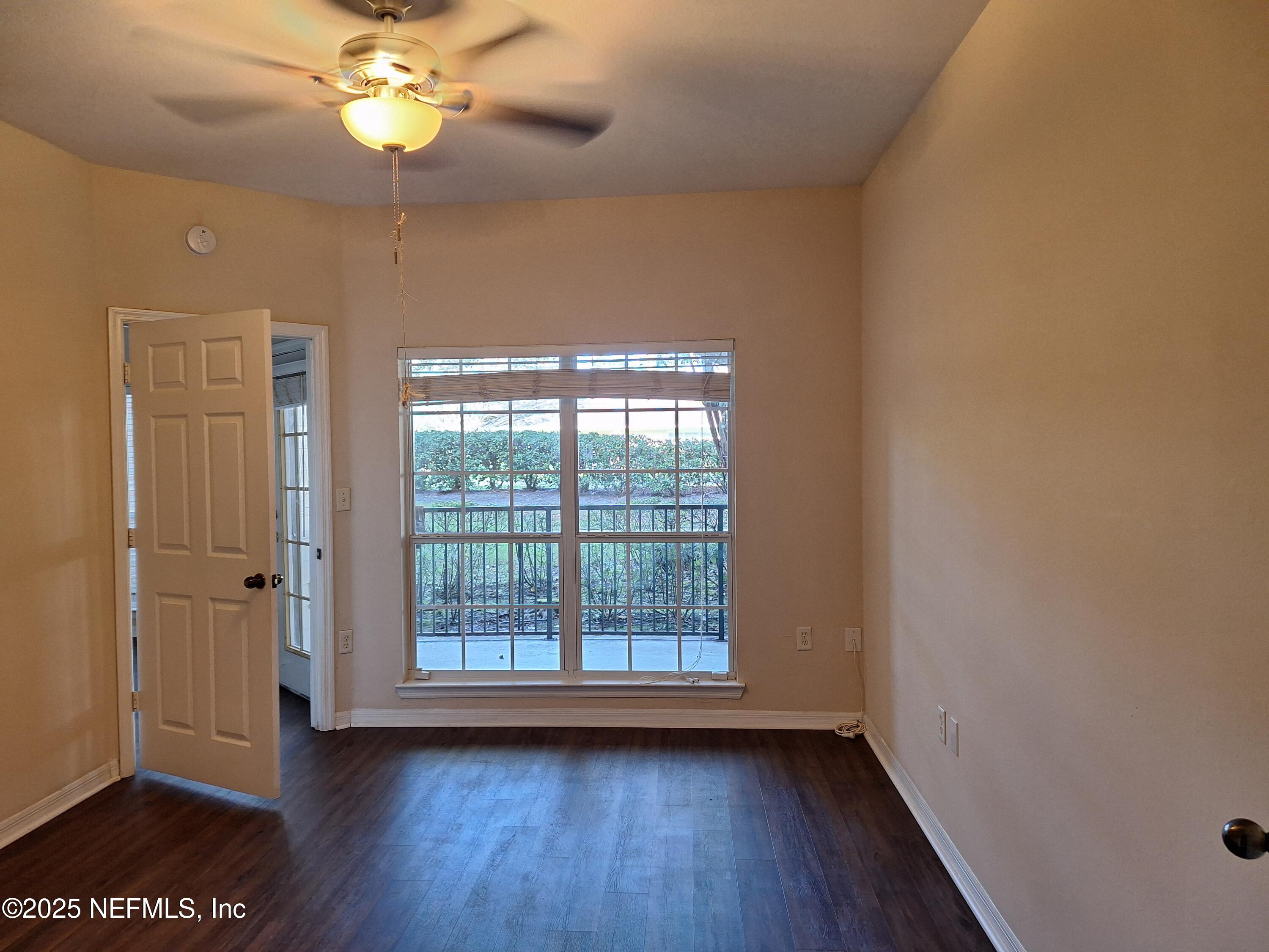 7800 Point Meadows Drive, Unit 116 Jacksonville, FL 32256 - Photo 8 of 29 a view of an empty room with a window and wooden floor