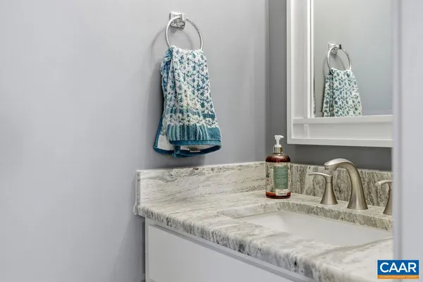 a bathroom with a granite countertop sink and a mirror