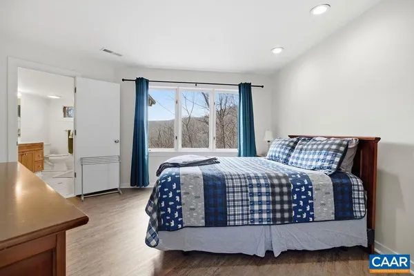 a bed sitting in a bedroom next to a window
