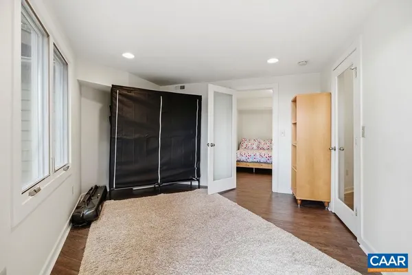 a view of hallway with wooden floor and cabinet