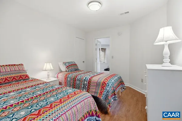 a bedroom with two beds and a lamp