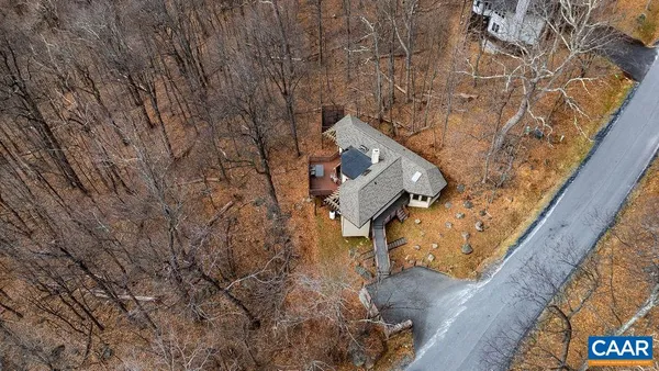 a view of a white house with a large tree next to a yard