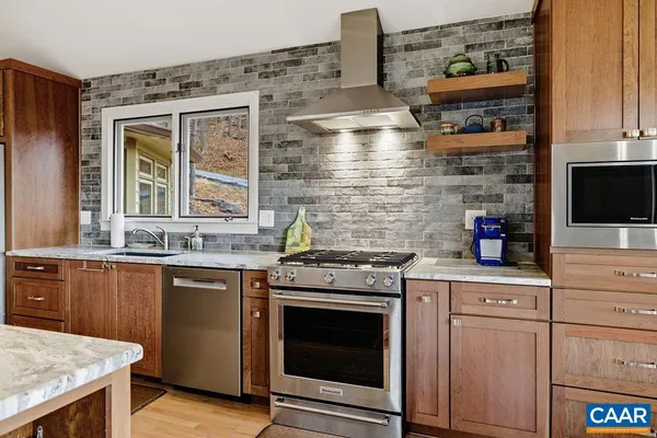 a kitchen with stainless steel appliances granite countertop a stove and a microwave