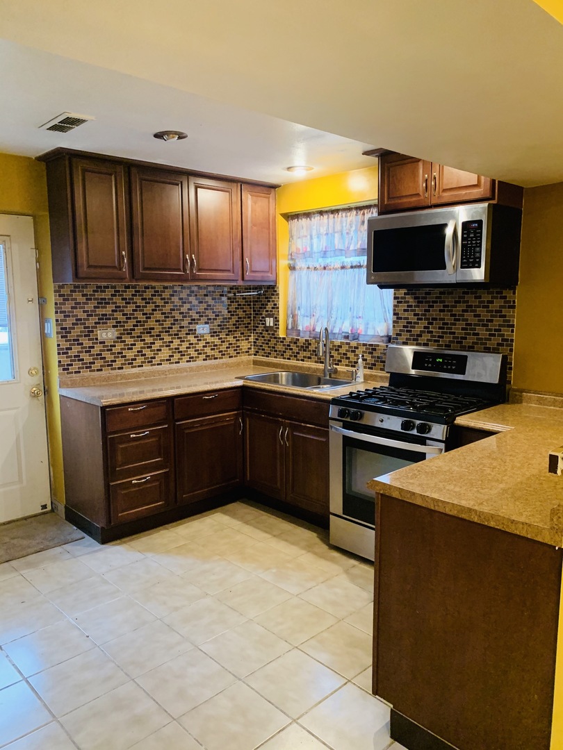 23 Surrey Road Montgomery, IL 60538 - Photo 3 of 22 a kitchen with stainless steel appliances a stove sink and microwave