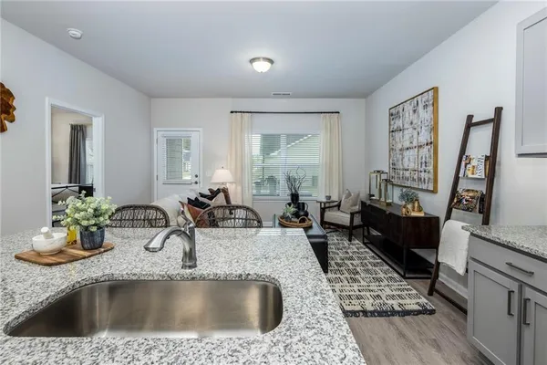 a kitchen with a sink a stove and a wooden floor