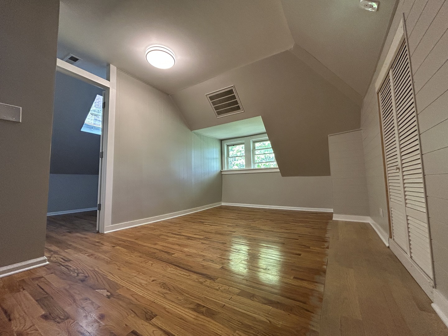 4834 North Ridgeway Avenue, Unit 3 Chicago, IL 60625 - Photo 10 of 12 an empty room with wooden floor and windows