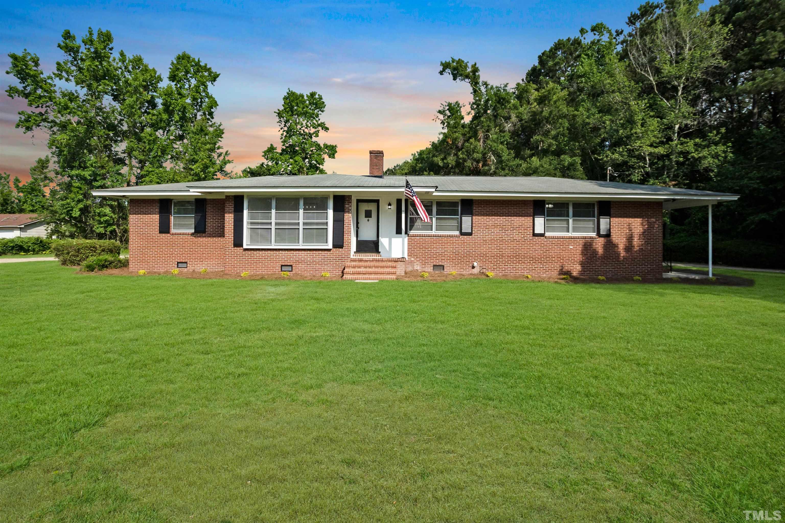 150 Community Drive Goldsboro, NC 27530 - Photo 2 of 30 a front view of a house with a garden and trees