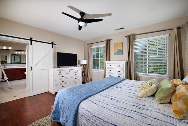 a bedroom with a bed a flat screen tv and a couch