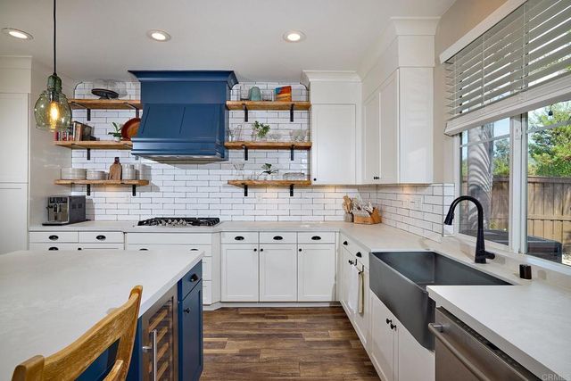 a kitchen with stainless steel appliances sink stove top oven and cabinets