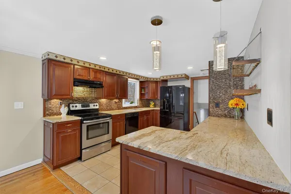 a kitchen with stainless steel appliances kitchen island granite countertop a sink counter space and cabinets