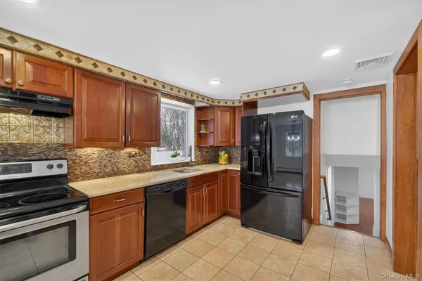 a kitchen with stainless steel appliances granite countertop a refrigerator and a stove top oven