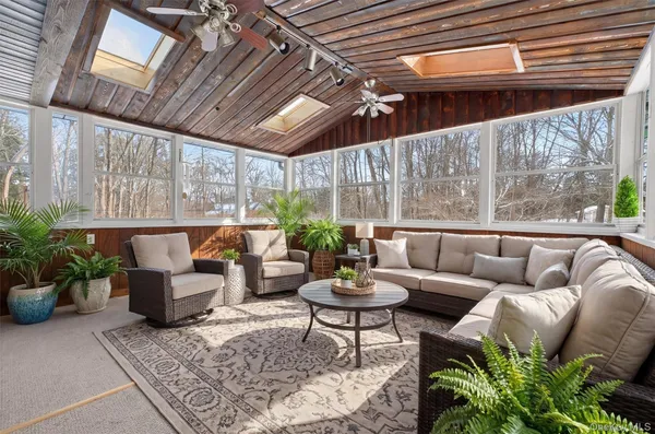 a living room with patio furniture and a potted plant