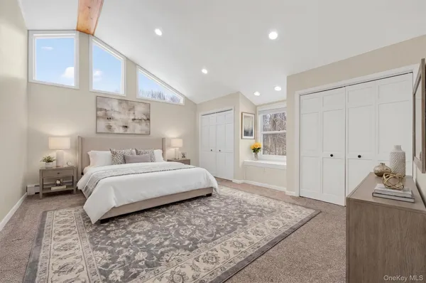 a spacious bedroom with a bed and a cabinet