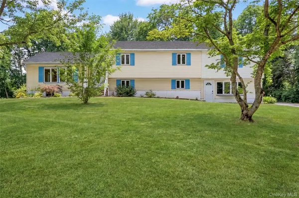 a view of a house with a big yard and large trees
