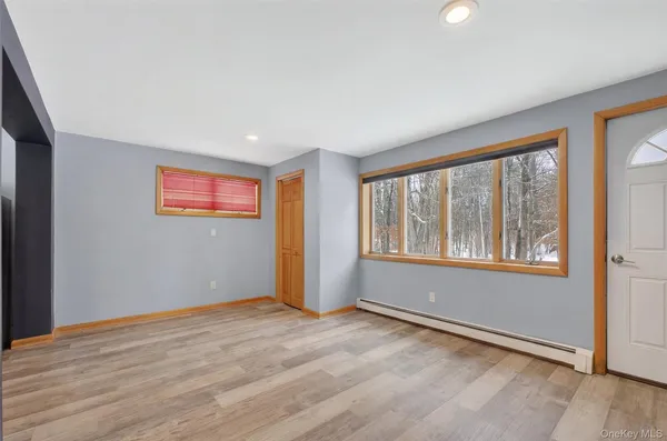 an empty room with wooden floor and windows
