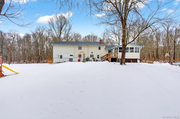 a view of the house with a yard covered in snow
