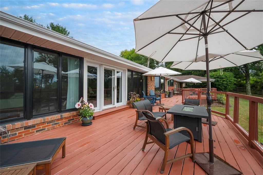 1000 Pleasant Hill Road Wexford, PA 15090 - Photo 24 of 37 a patio with wooden floor a yard a table and chairs under an umbrella